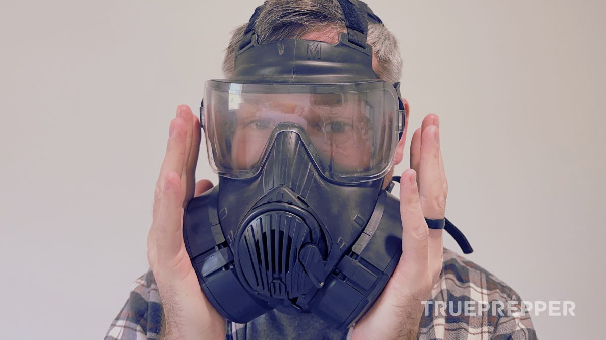 Sean covering both filters on the M50 gas mask demonstrating a negative-pressure fit test.