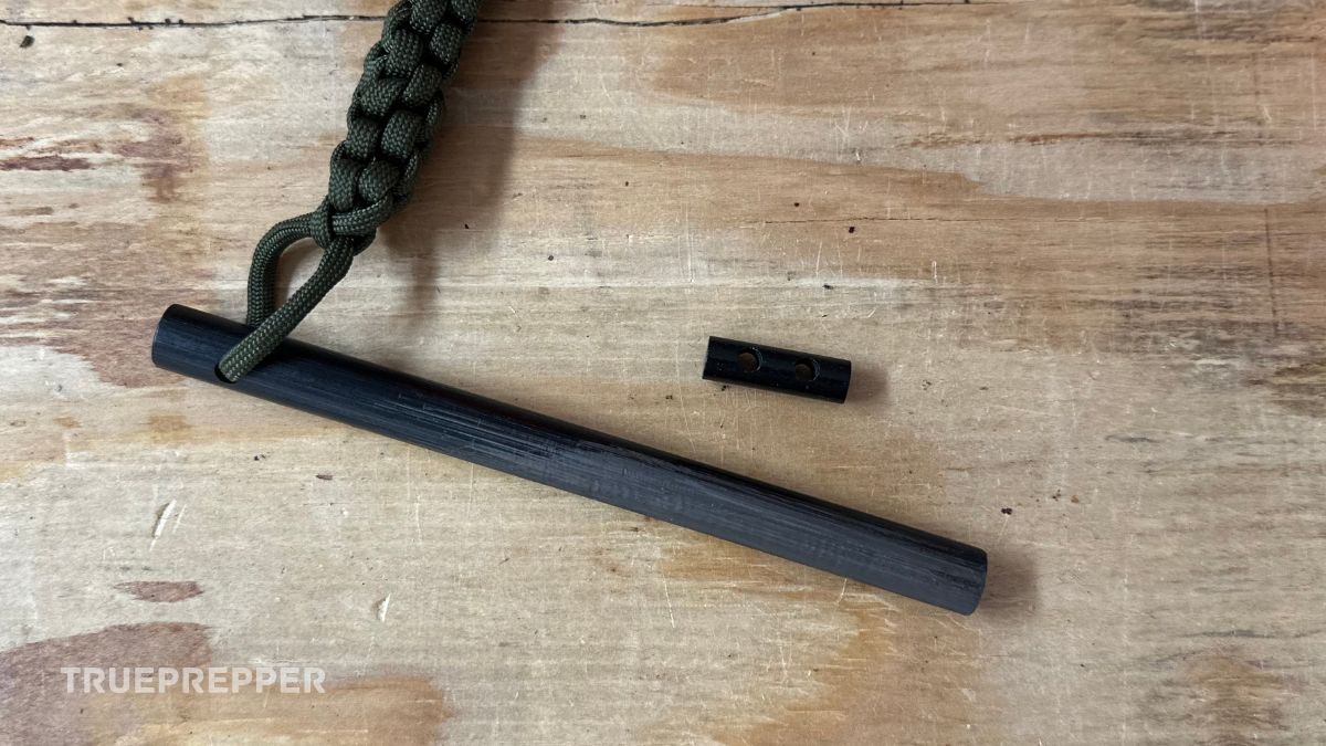 Small toggle hole Bayite ferro rod on plywood next to the larger six inch version with paracord lanyard.