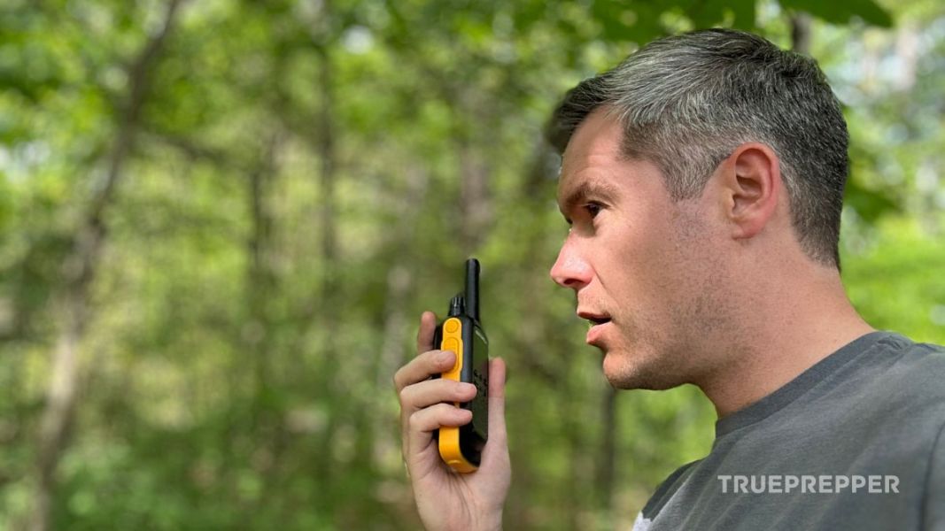 Sean holding the T470 walkie talkie up to speak in the woods.